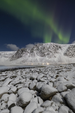 Aurora over Snowy Covered Boulders on Unstad Beach